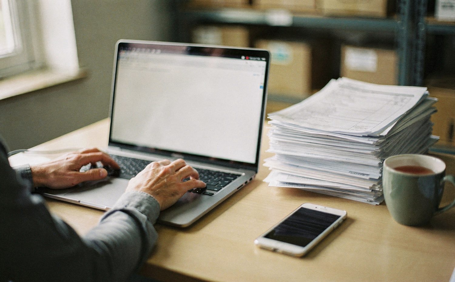 A depot office desk with a laptop and paperwork