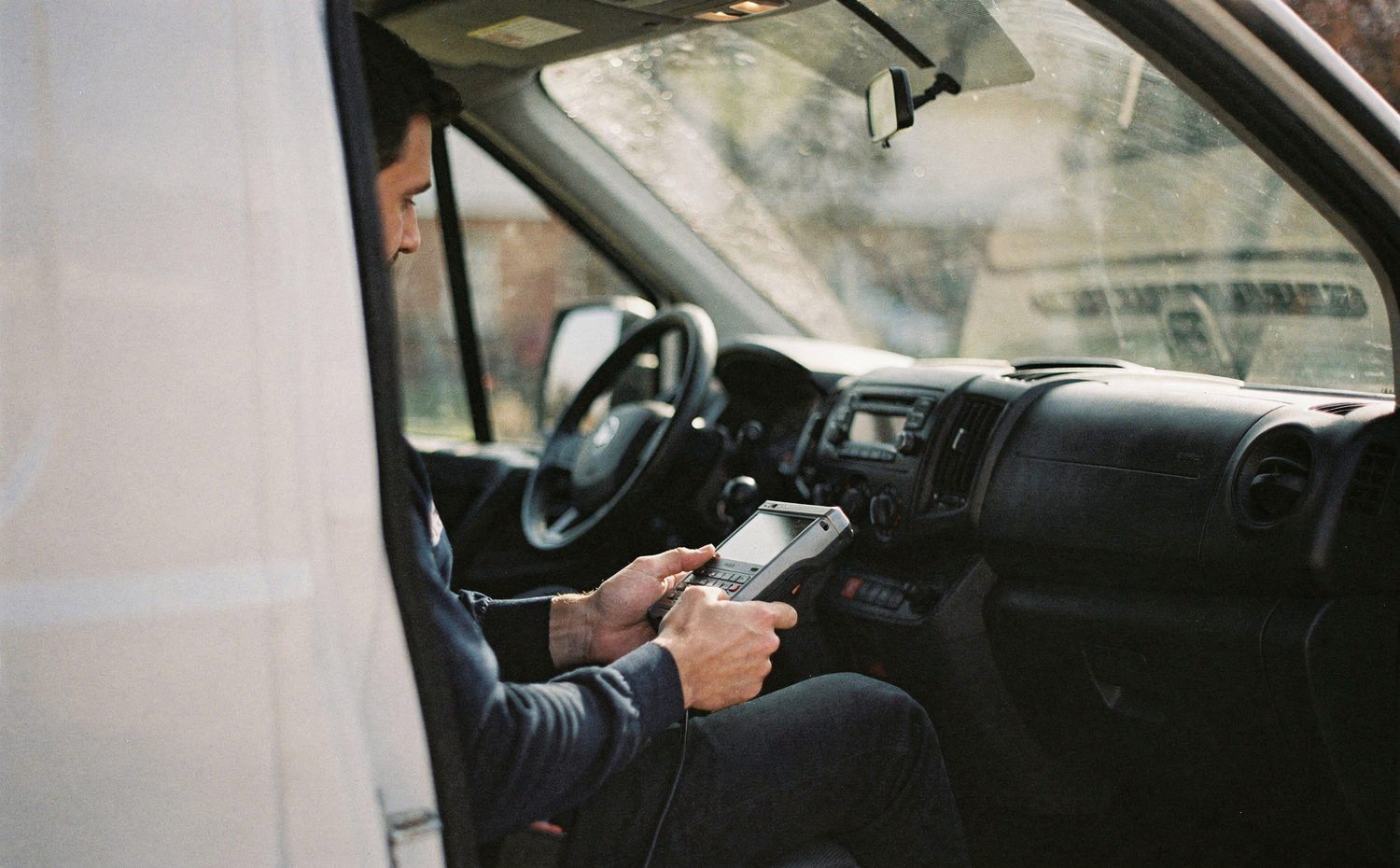 A delivery driver logging a parcel from the cab